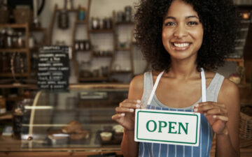 woman-holding-open-sign woman-holding-open-sign