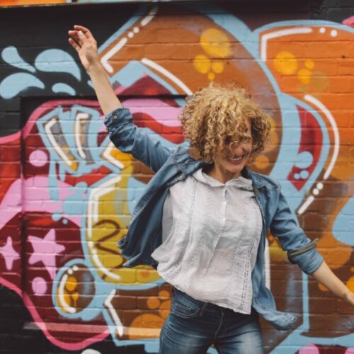Groß (frohliche-frau-tanzt-gegen-eine-graffiti-wand) Groß (frohliche-frau-tanzt-gegen-eine-graffiti-wand)